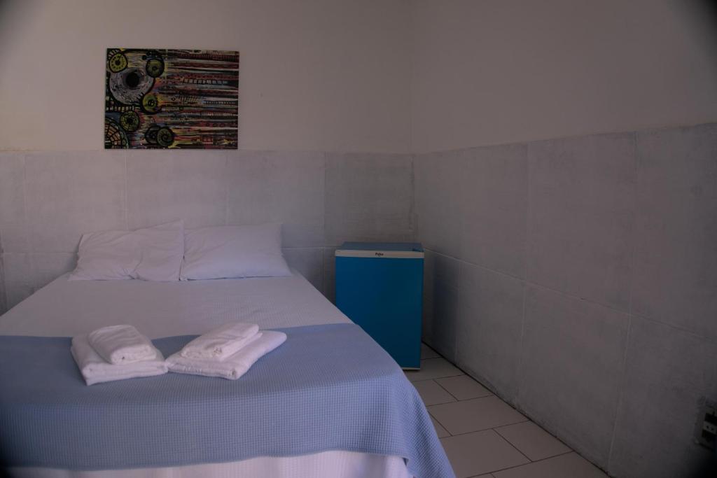 a bedroom with a bed with two towels on it at Casa da Lua Buzios in Búzios