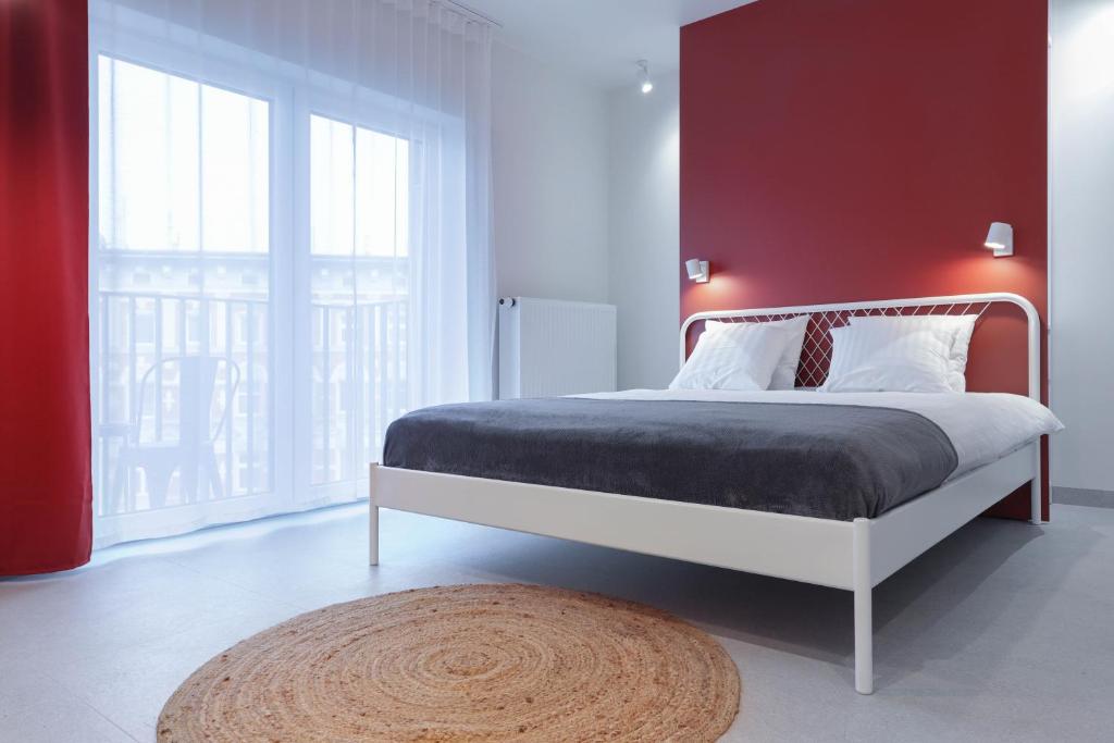 sypialnia z dużym łóżkiem i czerwoną ścianą w obiekcie Odra Apartments we Wrocławiu