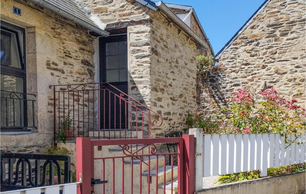 uma casa de tijolos com um portão vermelho e uma cerca branca em Amazing Home In Lannion With Kitchenette em Lannion