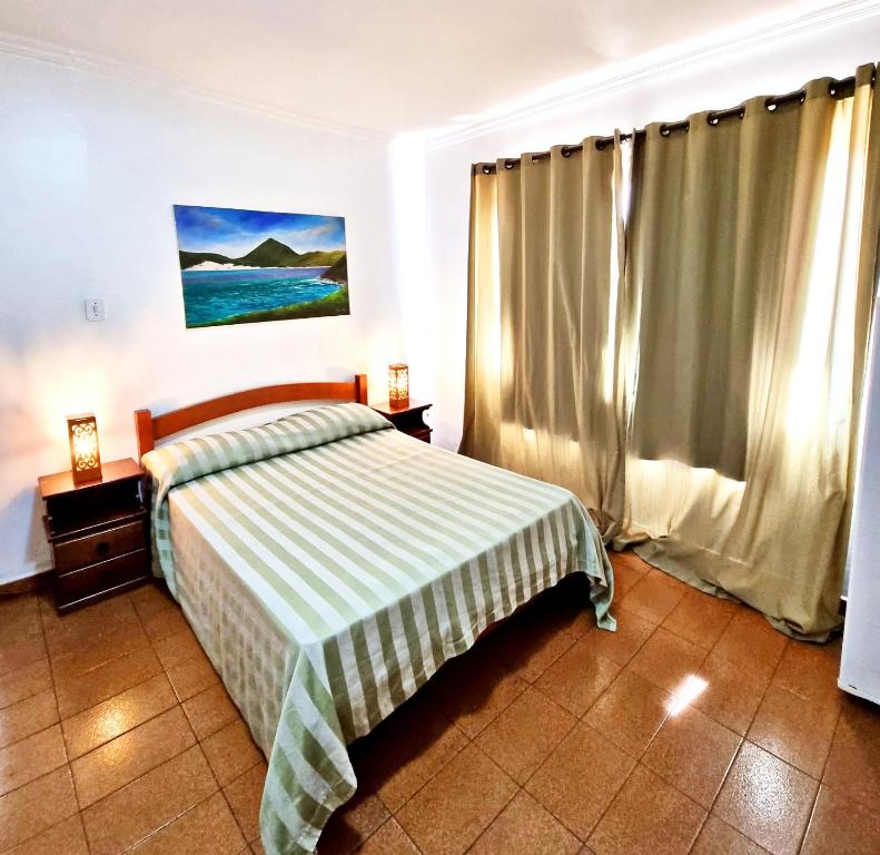 1 dormitorio con 1 cama con manta verde y blanca en Hotel da Canoa, en Arraial do Cabo