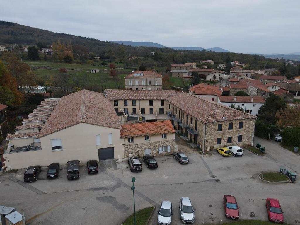 une vue aérienne sur une ville avec des voitures garées dans un parking dans l'établissement Beau logement 4 chambres, à Roisey