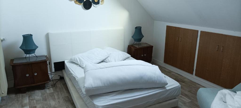 1 dormitorio con 1 cama con sábanas blancas y armarios de madera en L'auberge 10 à 15 pers 30min zoo beauval chambord cheverny en Langon