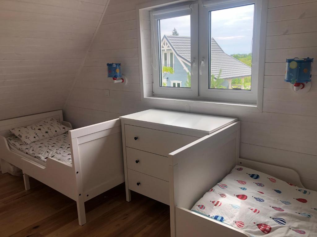 Habitación infantil con cama y ventana en Joniec Świata - 2 domy na wyłączność, en Joniec