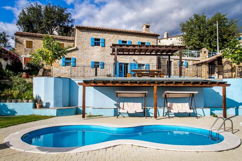 une villa avec une piscine en face d'une maison dans l'établissement Villa Viera, à Buzet