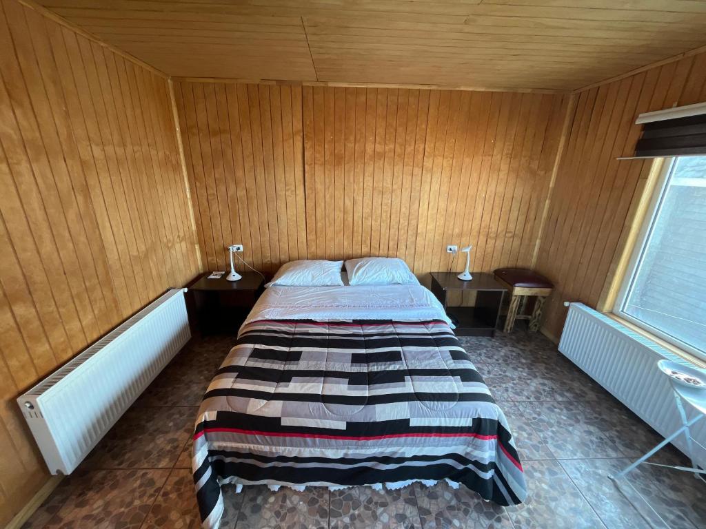 um quarto com uma cama num quarto com paredes de madeira em Loft 644 em Porvenir