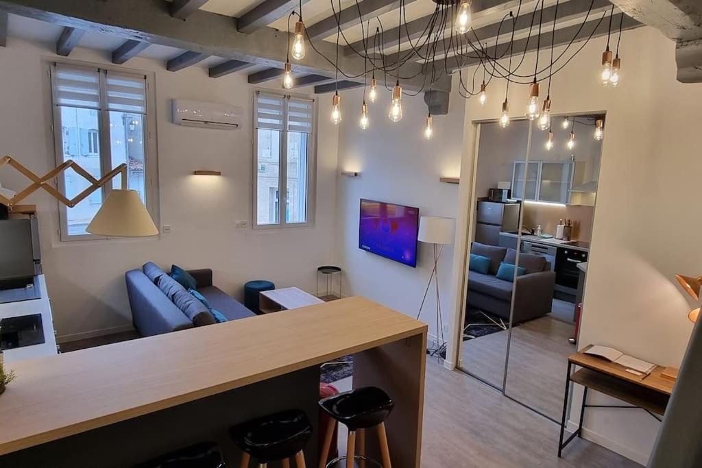 salon z niebieską kanapą i stołem w obiekcie Appartement climatisé entièrement rénové en hyper centre! Le Rétro Chic - Parking gratuit - Linge et serviettes inclus - w mieście La Roche-Chalais