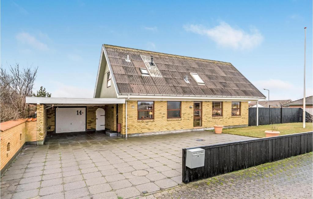 a yellow brick house with a large driveway at 4 Bedroom Nice Home In Skagen in Skagen