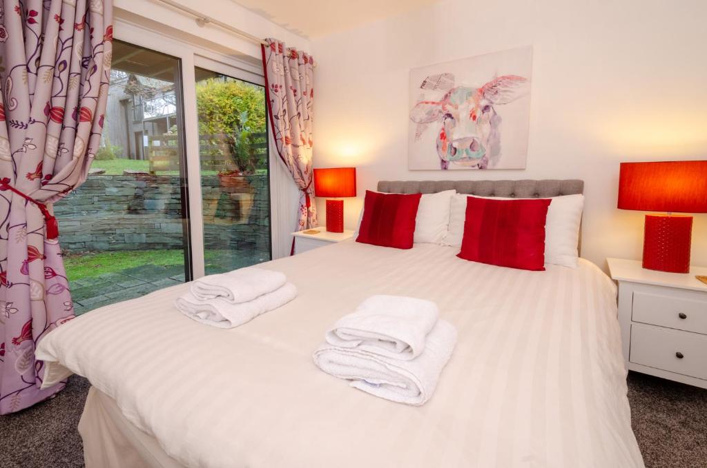 a bedroom with a white bed with towels on it at Squirrels in Elterwater