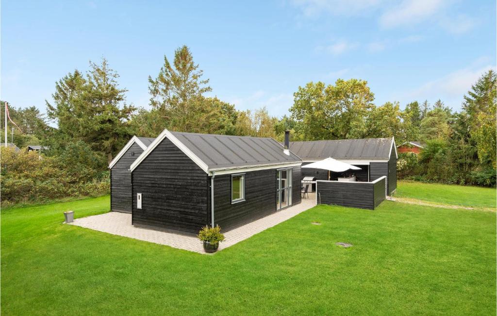 een zwart tiny house op een groen gazon bij Cozy Home In Lgstr With Kitchen in Løgstør