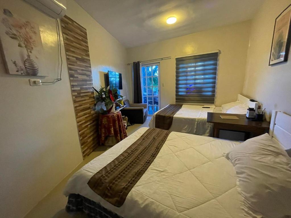 プエルト・ガレラにあるPhuenics de galeraのベッド2台とデスクが備わるホテルルームです。