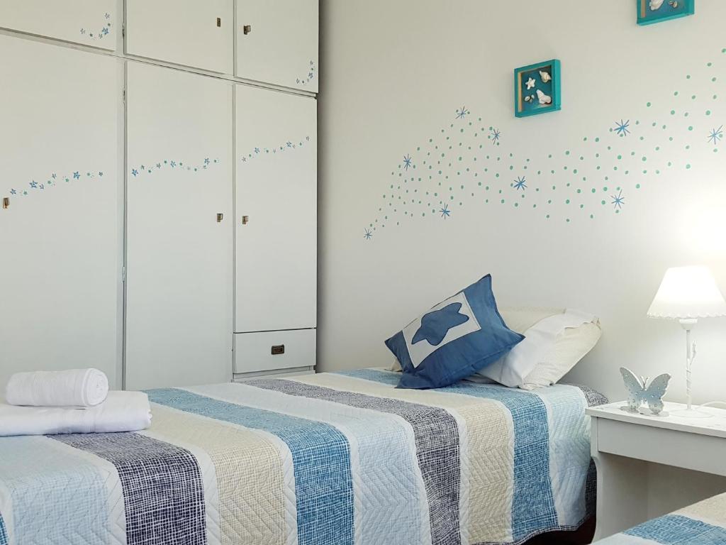 1 dormitorio con 2 camas con sábanas azules y blancas en Welcome MDP Solo familias en Mar del Plata