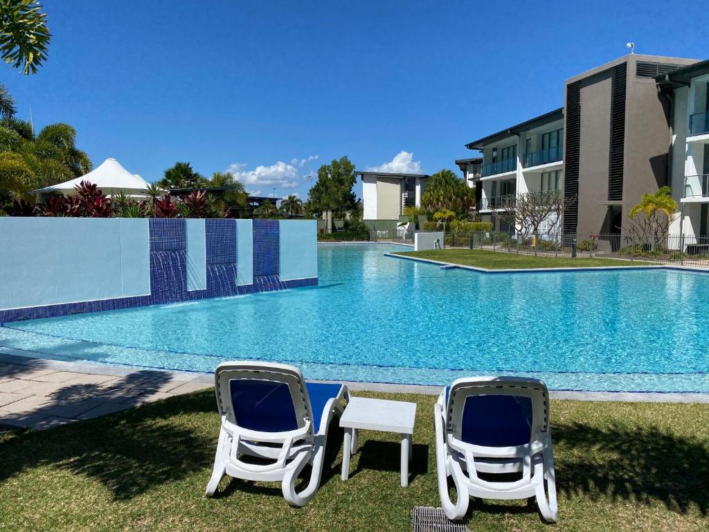 two chairs and a table in front of a swimming pool at Blue on Blue Studio Room 1272 in Nelly Bay