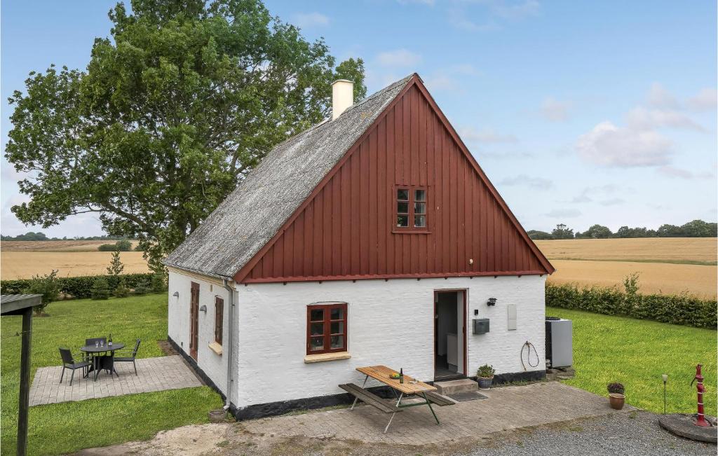 una pequeña casa blanca con techo rojo en Stunning Home In Bandholm With Kitchen en Bandholm