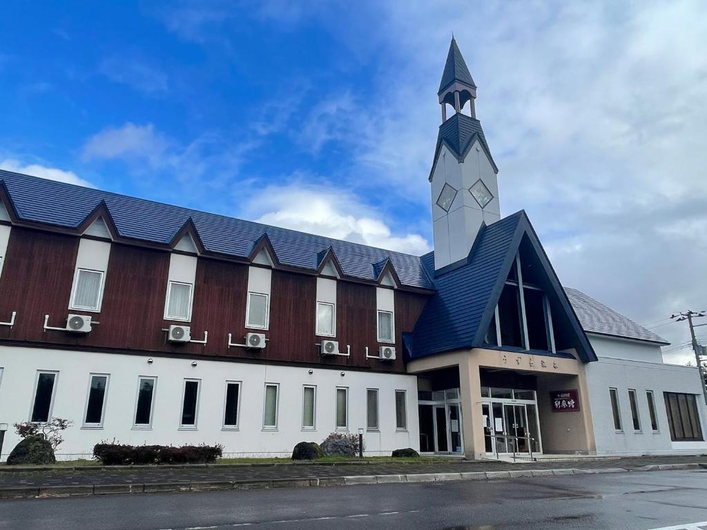 un gran edificio con una torre de reloj encima en Assabu Uzura Onsen Shiki no Yado, 