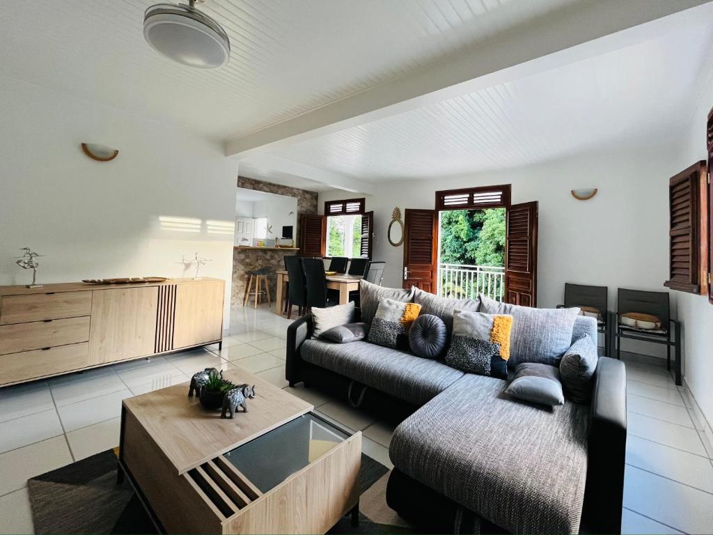 ein Wohnzimmer mit einem Sofa und einem Tisch in der Unterkunft Appartement Manou in Le Lamentin