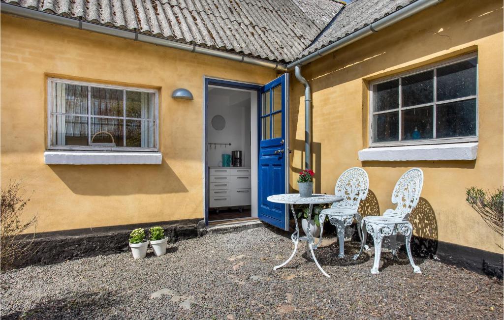 a patio with two chairs and a table in front of a house at 2 Bedroom Beautiful Apartment In Rnne in Rønne