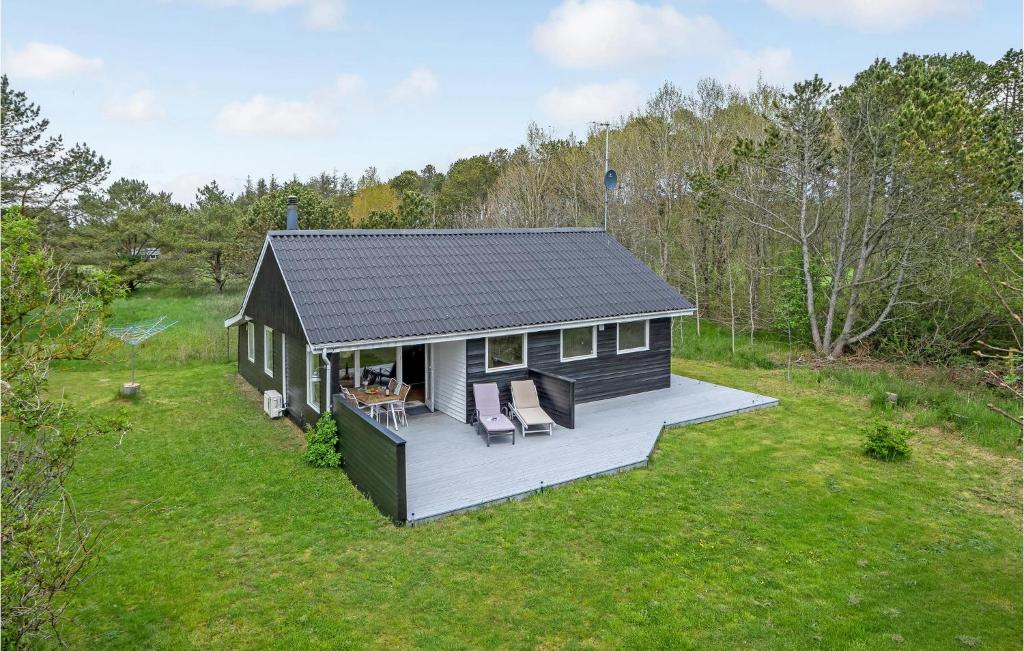 a small house with a deck in a field at 3 Bedroom Pet Friendly Home In Ålbæk in Ålbæk