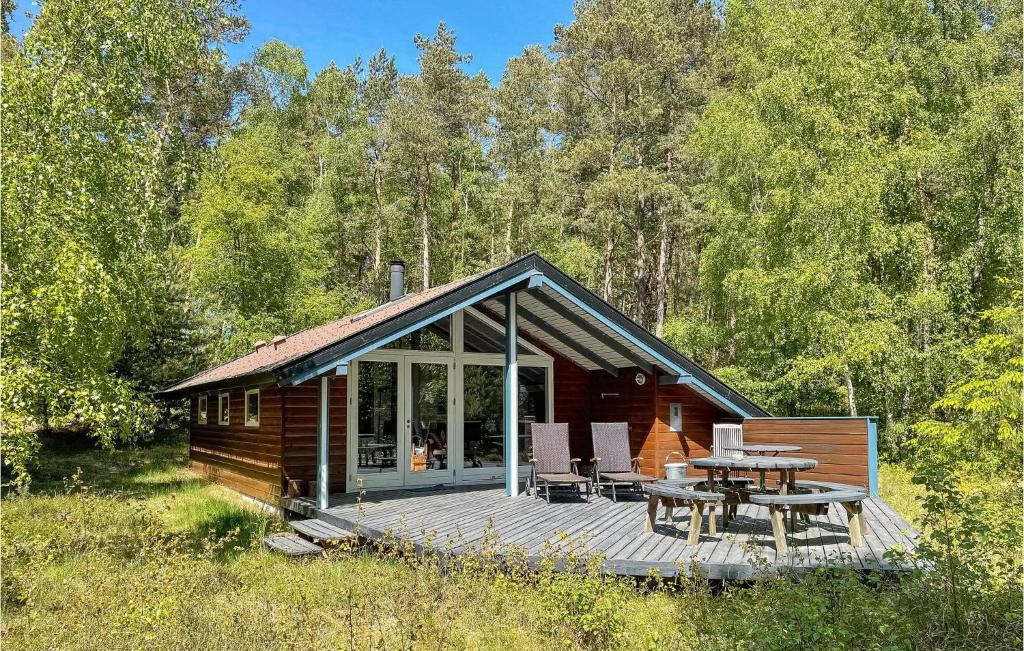 a log cabin with a deck and a table at Stunning Home In Nexø With Kitchen in Neksø