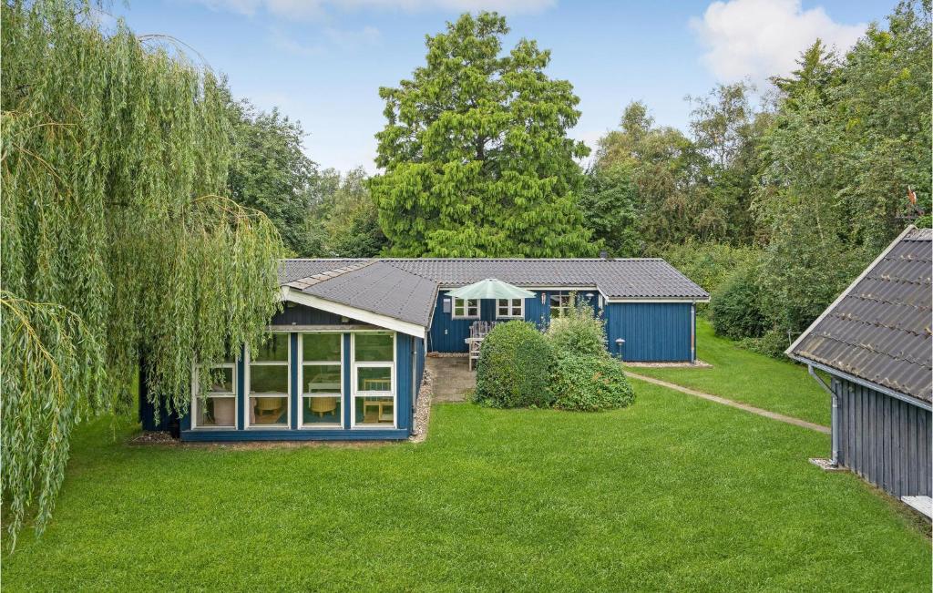 a blue house in the middle of a yard at 3 Bedroom Lovely Home In Store Fuglede in Store Fuglede