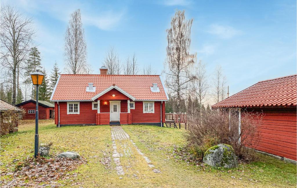 a red house with a red roof in a yard at 5 Bedroom Awesome Home In Kopparberg in Ställdalen