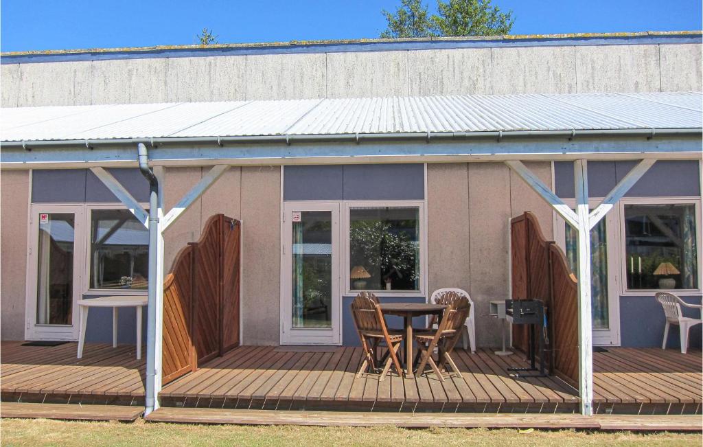 ein Haus mit einer Holzterrasse mit einem Tisch und Stühlen in der Unterkunft Amazing Apartment In Nexø With Sauna in Neksø