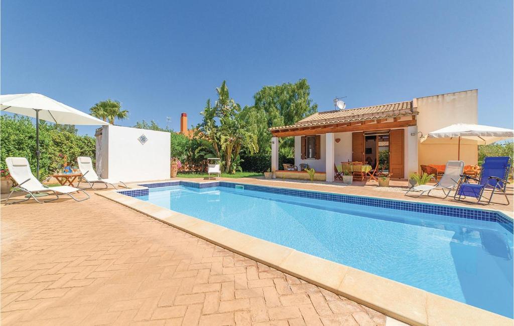 a swimming pool with chairs and a house at Villa Gina in Menfi