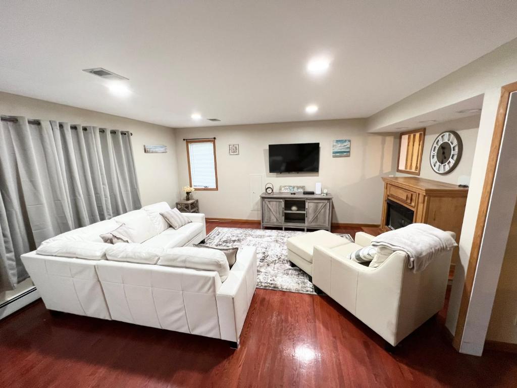 sala de estar con 2 sofás blancos y TV en Shore house on Pelican Island!, en Seaside Heights