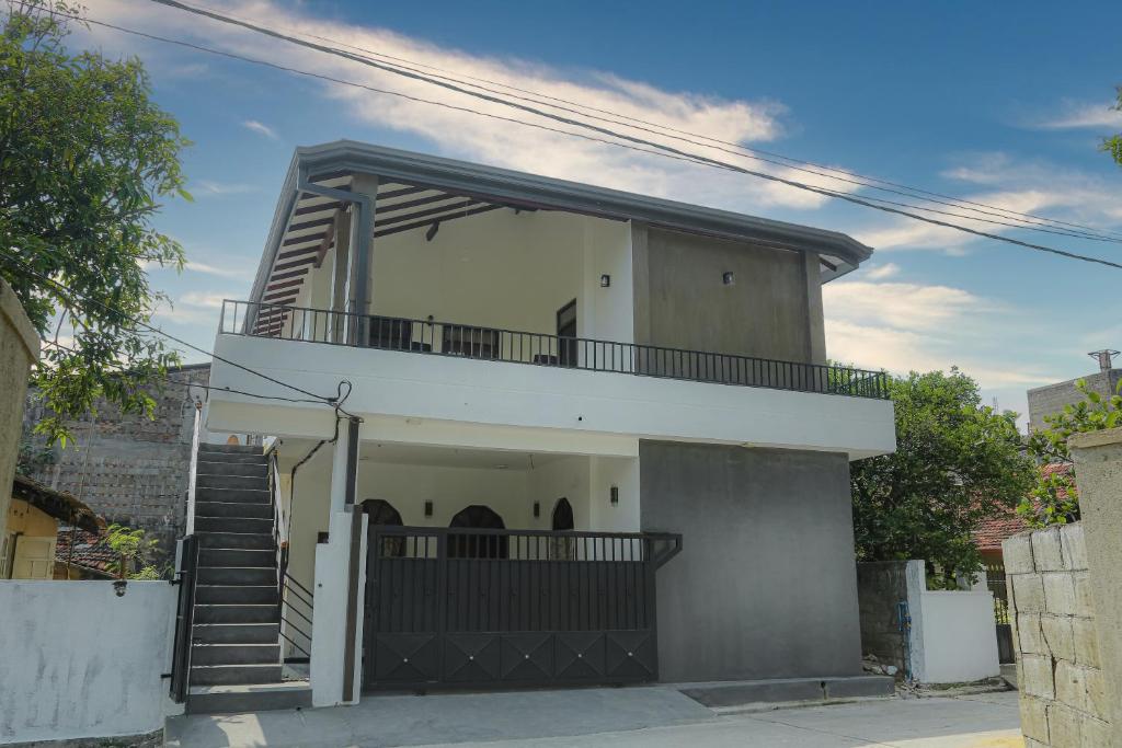 a white house with a balcony on top of it at Star Canal Cottage in Negombo