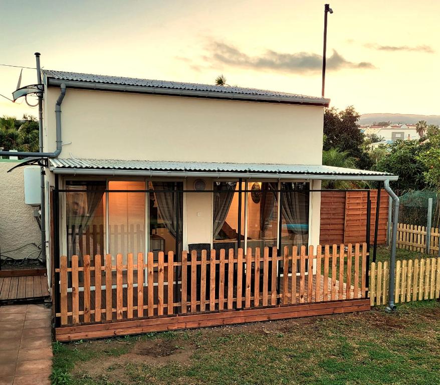 a house with a fence in front of it at Tiny House Chaleureuse au Style Contemporain Minimaliste in Le Tampon