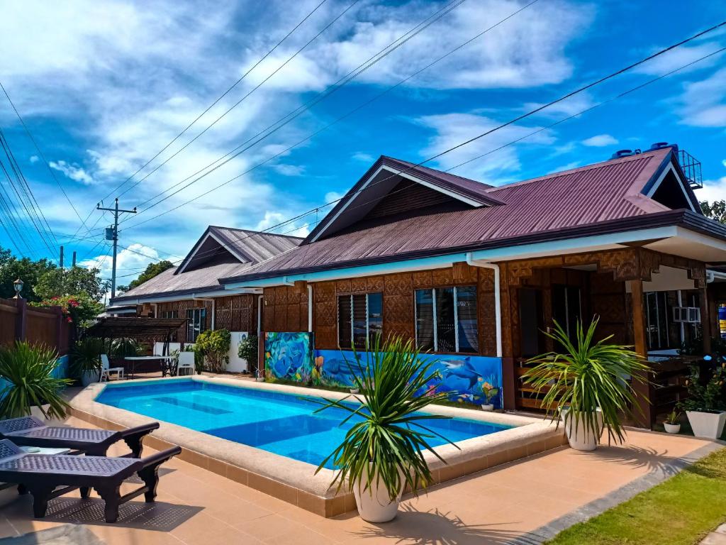 una casa con una piscina di fronte di Dolce Vita Resort a Moalboal