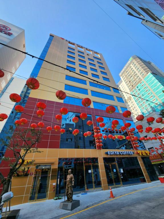 un edificio con sombrillas rojas colgando delante de él en Gold Stone Hotel, en Busan