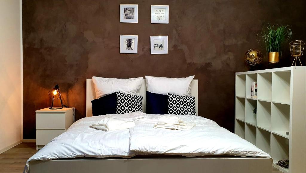 een slaapkamer met een bed met witte lakens en kussens bij ☆WOW! Stylish Studio in Centre Near University☆ in Mannheim