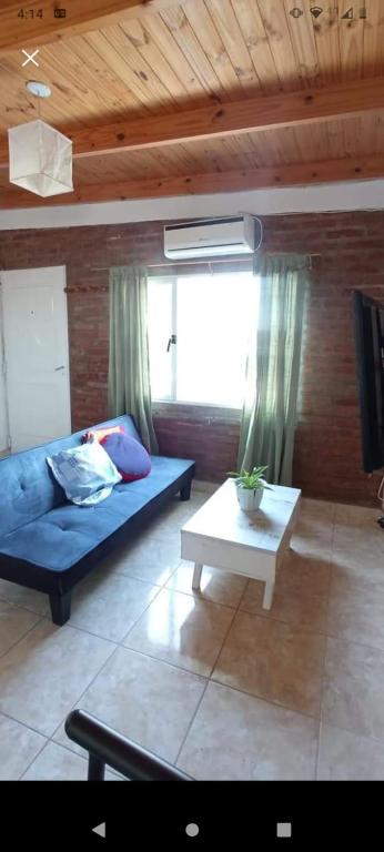 a living room with a blue couch and a table at Departamento en Trelew in Trelew