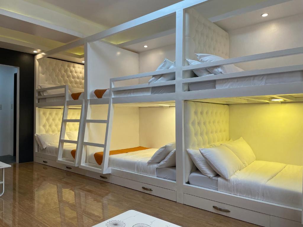 two bunk beds in a room with white furniture at Rangya Hotel in Tagaytay