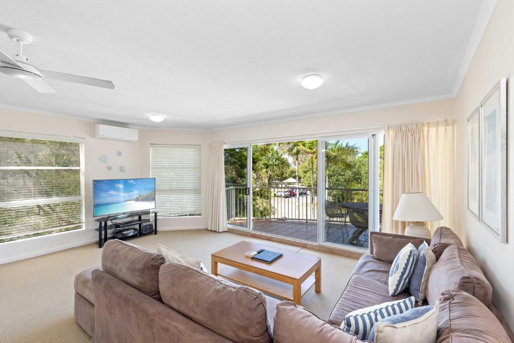 a living room with a couch and a tv at Rivershores in Noosaville