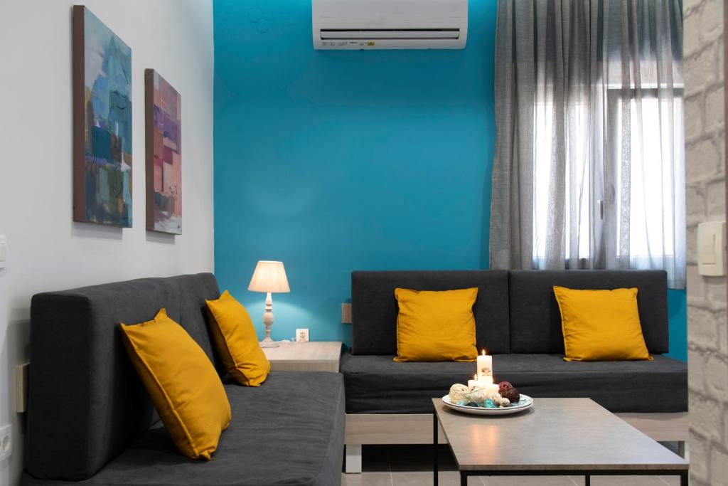 a living room with a black couch and yellow pillows at Chania Design Suites in Chania
