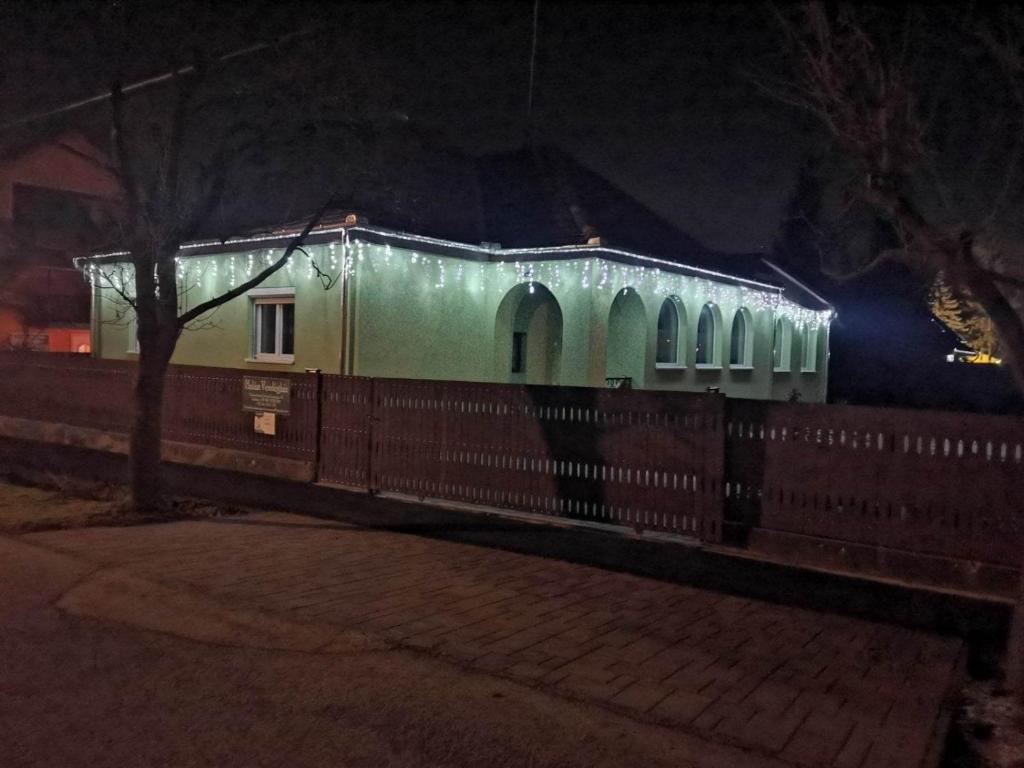 Un tren cubierto de luces de Navidad por la noche en Halász Vendégház en Szilvásvárad