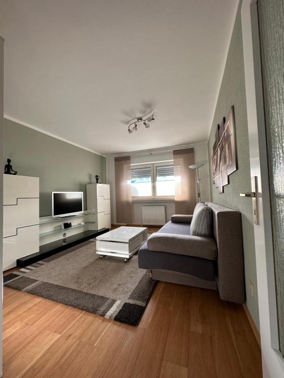 a living room with a couch and a tv at FeWo-City in Gießen