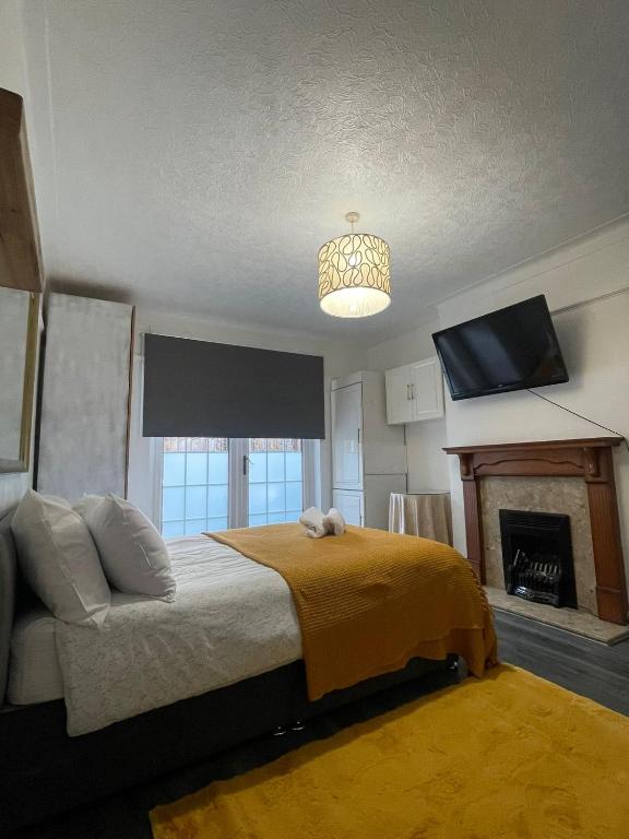 a bedroom with a bed and a tv and a fireplace at Beautiful Private Rooms in London Central Willesden Green in London