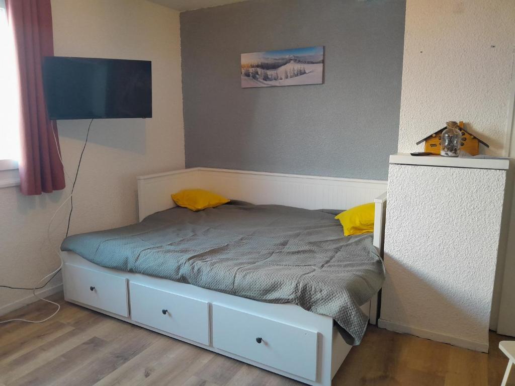małe łóżko w pokoju z telewizorem w obiekcie Studio du lac bleu w mieście Morillon