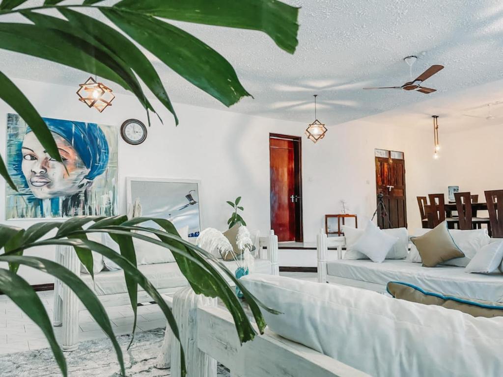 a living room with two beds and a plant at Milamax Beach Vllla in Diani Beach