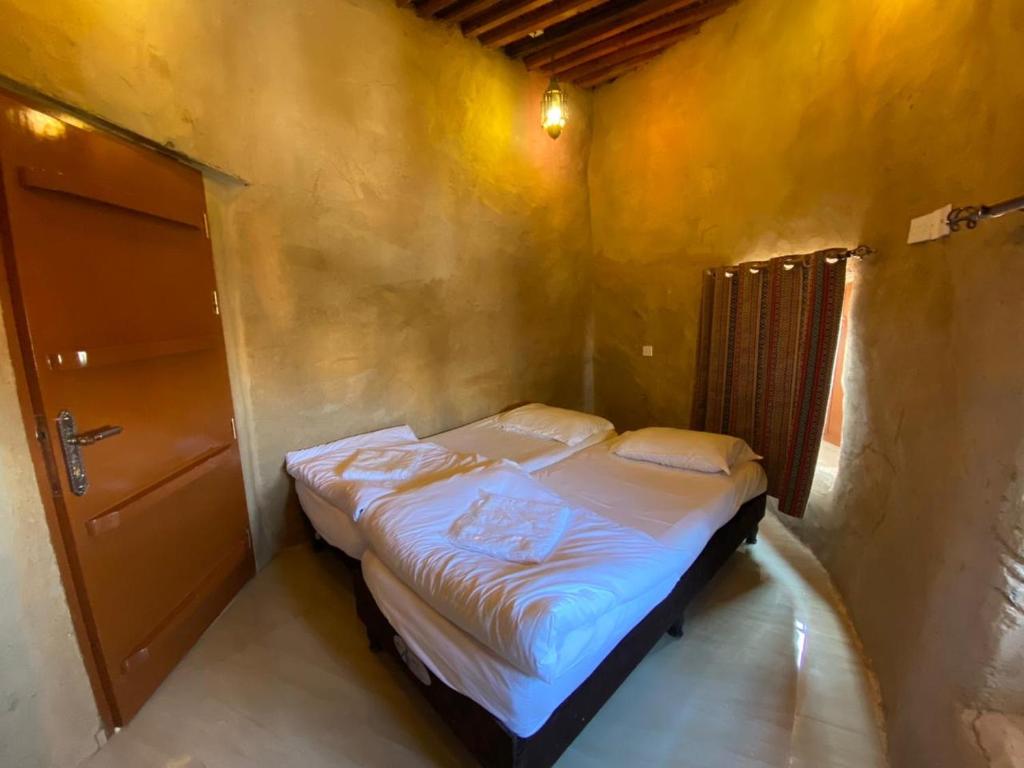 Una cama o camas en una habitación de Hissen Al-Misfah