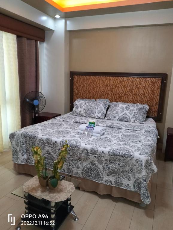een slaapkamer met een groot bed met een deken en kussens bij CondoTel Pasay Newport City in Manilla