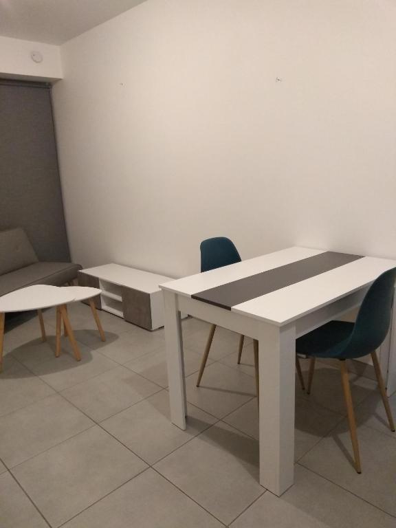 een kamer met een tafel, 2 stoelen en een bank bij Studio de charme à la campagne in Clayes