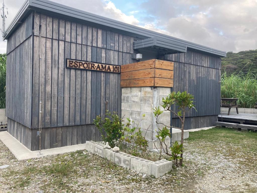 a wooden building with a sign on the side of it at エスポアールあま in Ama