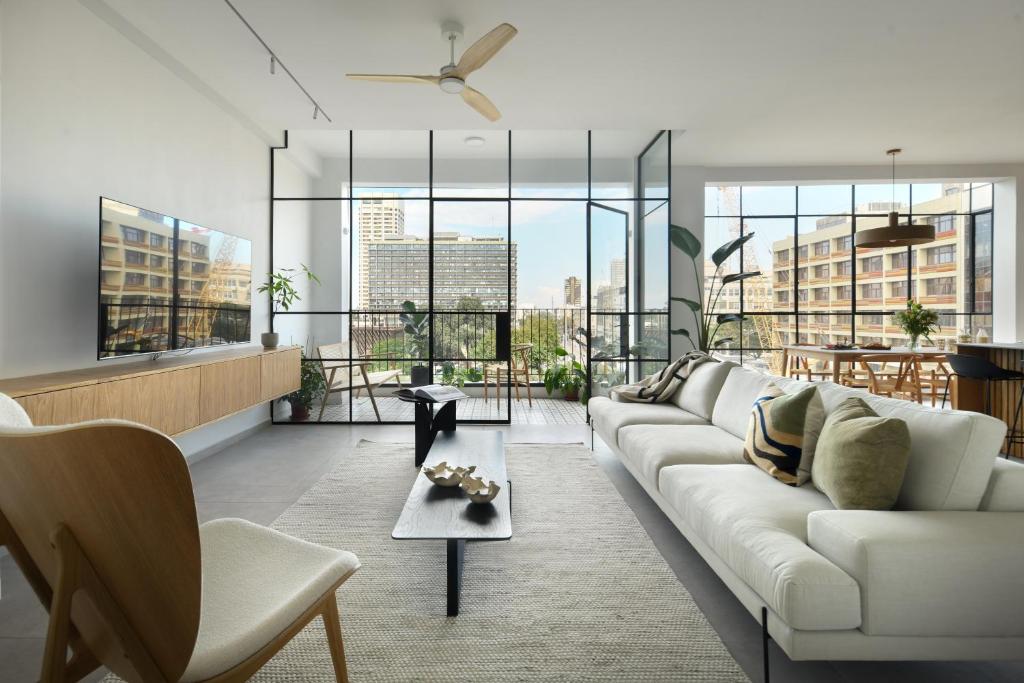 a living room with a white couch and some windows at Picturesque 3BR Apt w Panoramic Views in Tel Aviv by Sea N' Rent in Tel Aviv