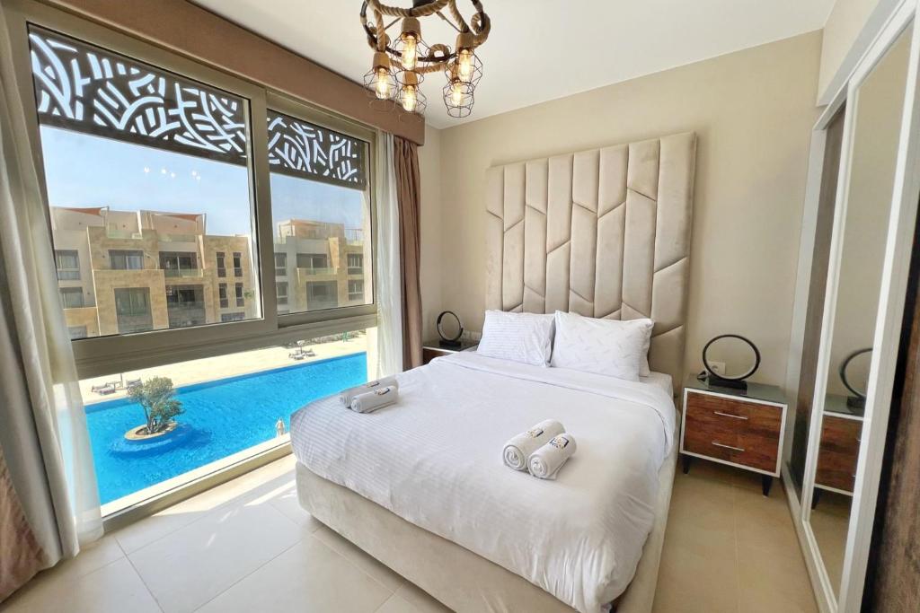 sypialnia z łóżkiem i dużym oknem w obiekcie Charming 2BDR w Sea & Pool View Free Beach & Pool Access w mieście Hurghada