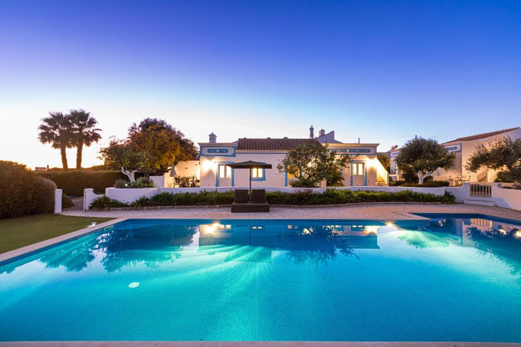 a large swimming pool in front of a house at Casa Flor de Sal in Moncarapacho