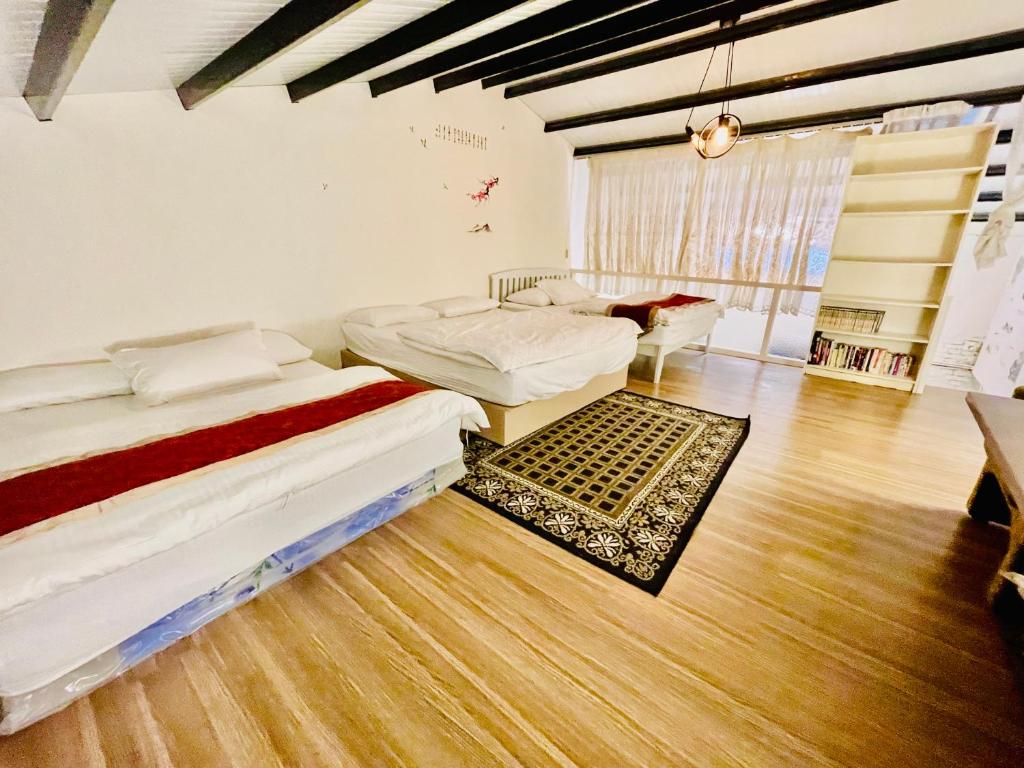 Habitación con 2 camas y suelo de madera. en Yilan Night Market Whole House, en Yilan City
