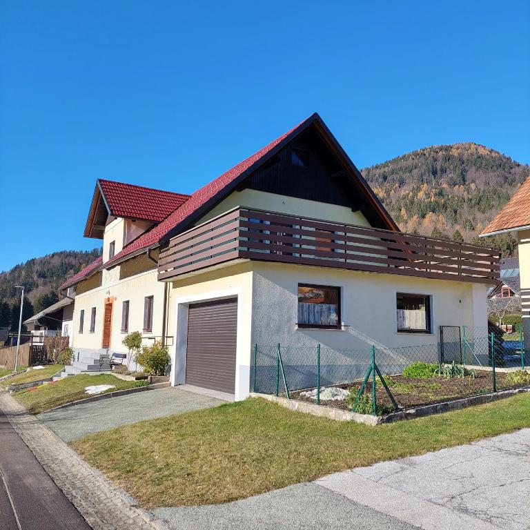 une maison avec une clôture devant elle dans l'établissement Apartmaji Biseri, à Kranjska Gora